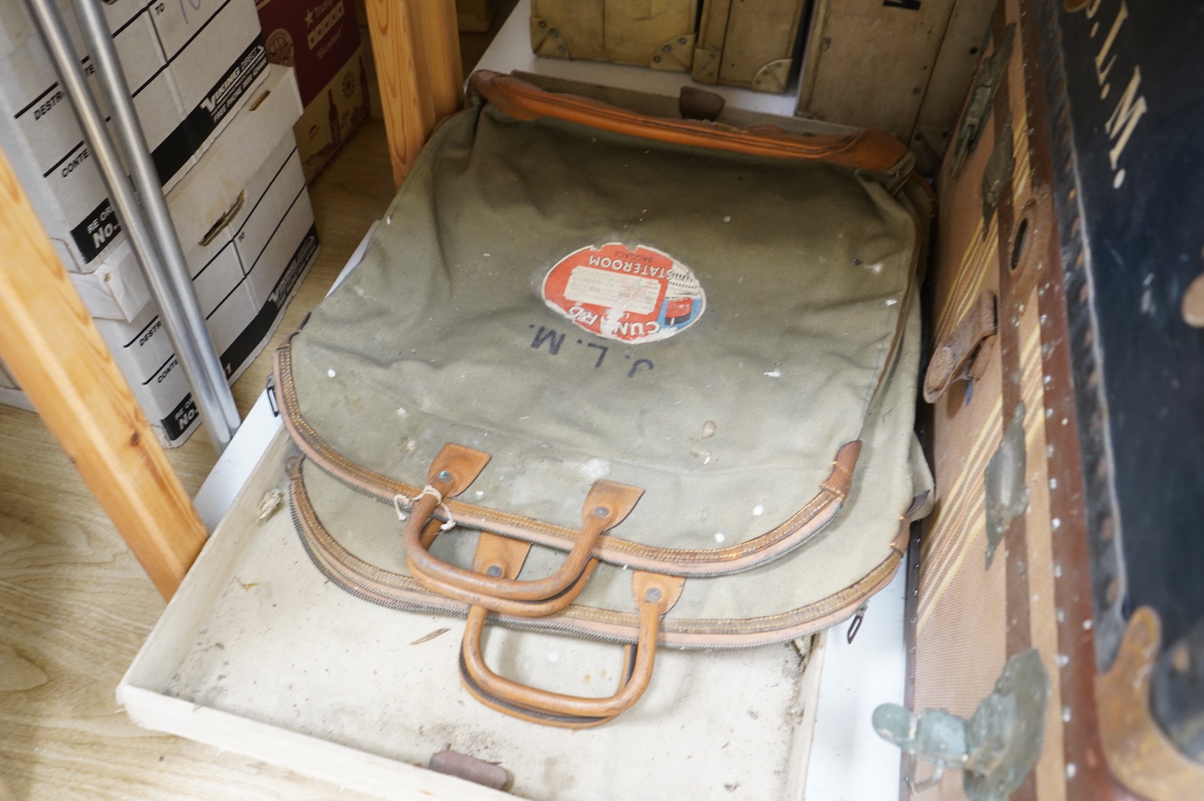 A collection of vintage luggage comprising four early 20th century bound travelling trunks and three kit bags
